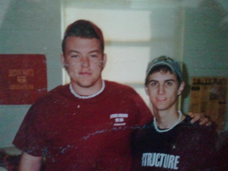 Two college students, Shaun (R) and his friend Sean, standing together in a dorm room at Southern Miss in 2002. The photo has visible gray water damage marks from Hurricane Katrina.