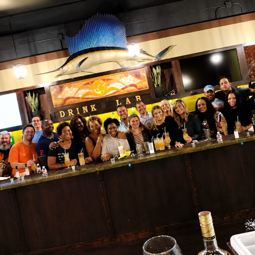 Group of guests enjoying a hands-on mixology class at Drink Lab New Orleans, learning to craft classic New Orleans cocktails.